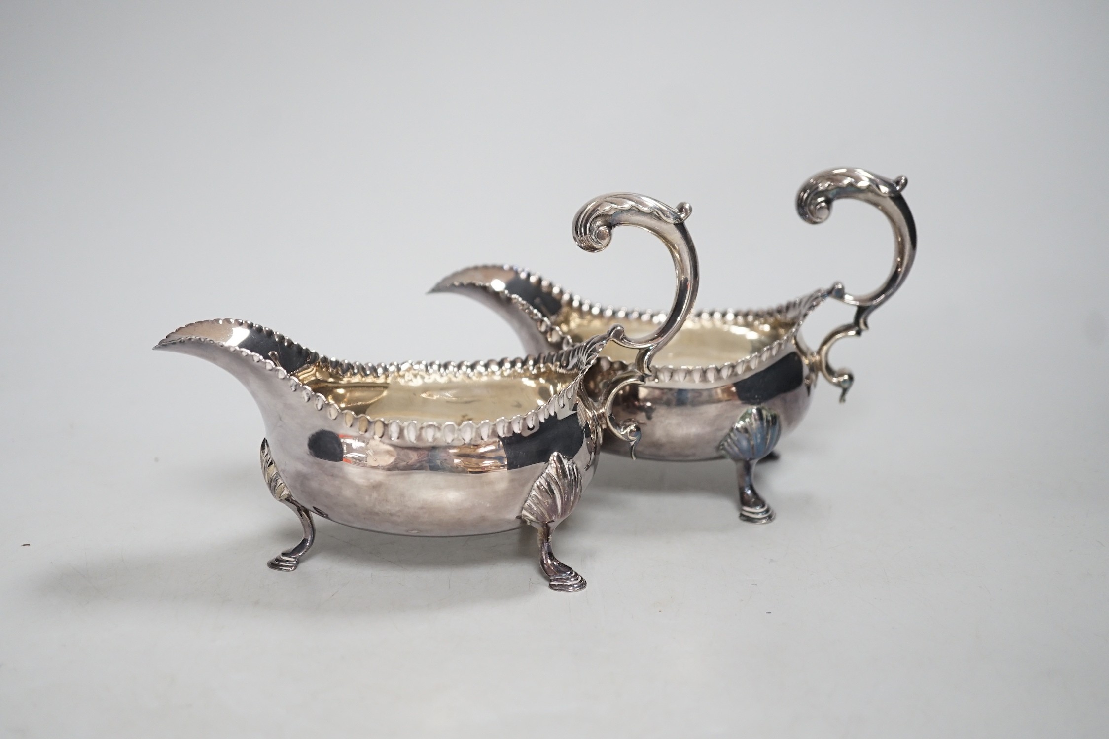 A pair of early George III silver sauceboats, with flying scroll handles, maker, CH, London, 1768, length 15.5cm, 10.4oz.